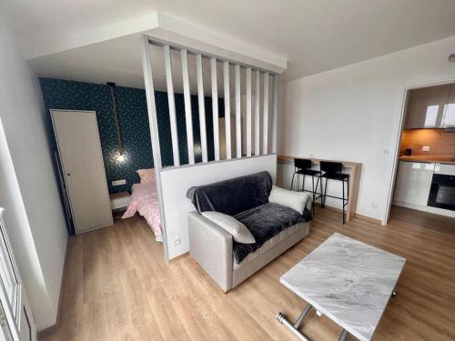 - un salon avec un canapé et une chambre dans l'établissement Appartement proche des prébendes, à Tours