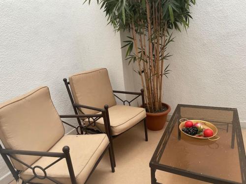 Studio N•2 avec patio en plein cœur de la ville في بانيير-دوبيغور: كرسيين وطاولة مع صحن من الفاكهة