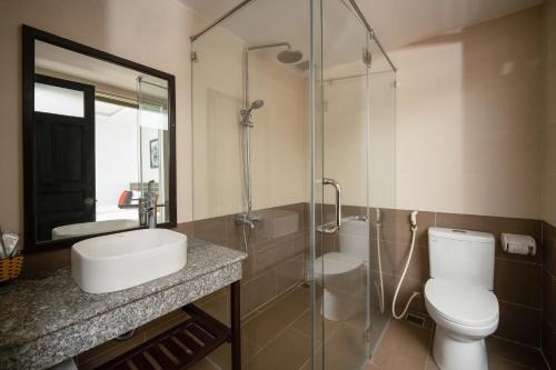 e bagno con servizi igienici, lavandino e doccia. di Viet Long Hoian Beach Hotel - STAY 24H a Hoi An