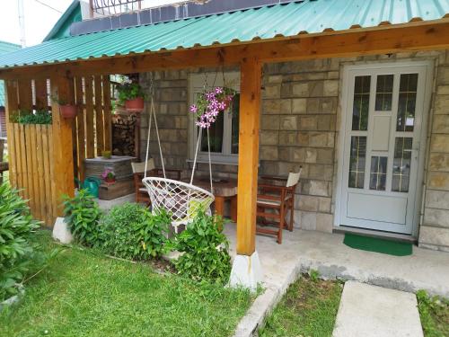 a wooden pergola with a table and a swing at Duke in Žabljak