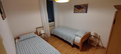 a room with two beds and a window at Apartma 2000 Tolmin in Tolmin