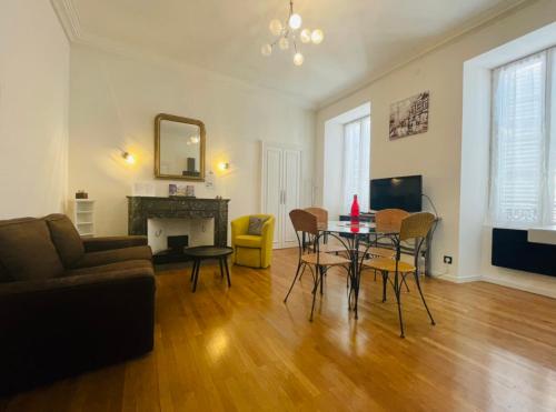 a living room with a table and a couch at Le Payan in Gap