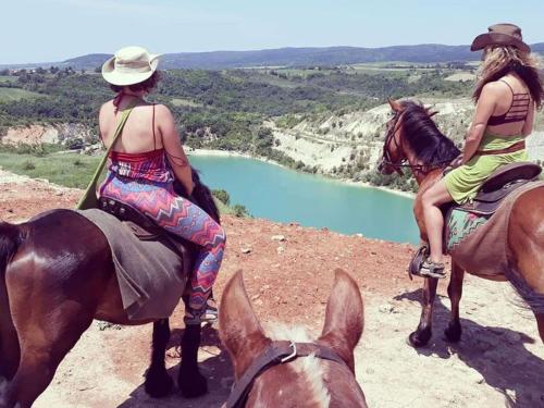 two women are riding on horses near a river at Brvnara Beli Kamen 2 in Sremska Mitrovica