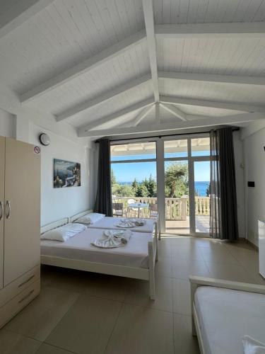 a bedroom with a bed with a view of the ocean at Essos Villas in Dhërmi