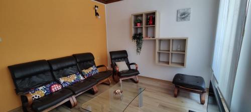 ein Wohnzimmer mit einem Sofa und 2 Stühlen in der Unterkunft Apartma 2000 Tolmin in Tolmin