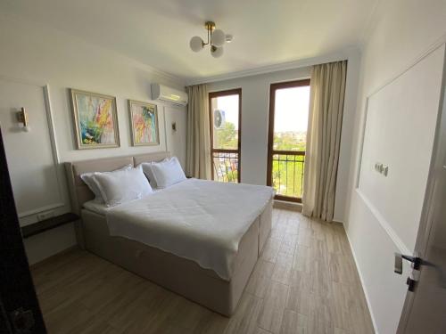 a bedroom with a white bed and a window at LUXURIOUS COMFORT IN CASCADAS in Sunny Beach