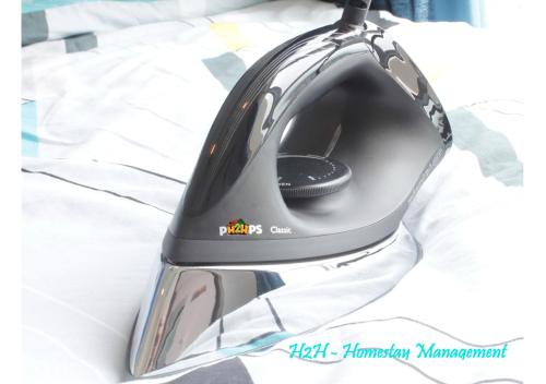 a black and silver helmet sitting on a bed at H2H - Holland Cottage - Majestic Ipoh - 7pax in Ipoh