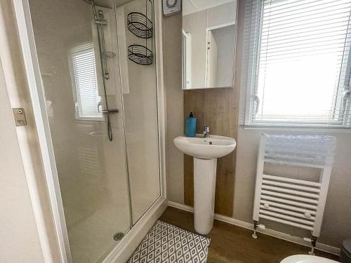 y baño con ducha y lavamanos. en Beautiful 6 Berth Caravan With Decking In Norfolk Ref 89001mv en Belton