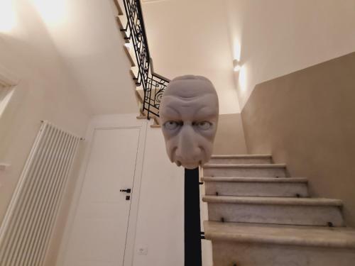 a mask in a hallway with a stair case at Allegra Viareggio Appartamento & Affittacamere Guest house in Viareggio