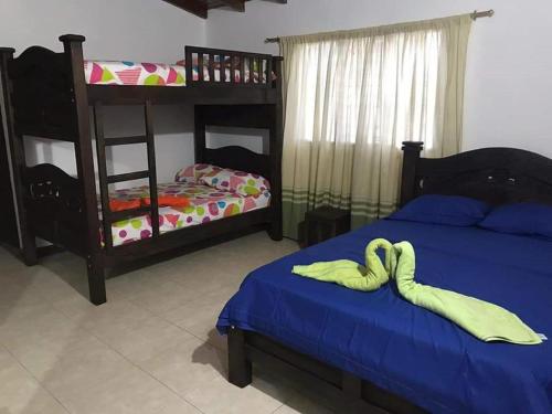 a bedroom with two beds and a bunk bed at Hotel La Casona in Chinácota