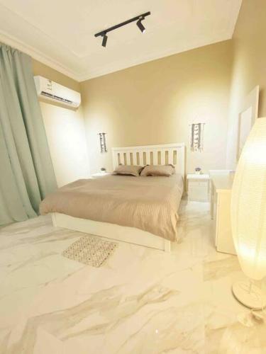 a white bedroom with a bed and a ceiling at Smart Entry Apartment w Pvt Entrance 3B in Riyadh