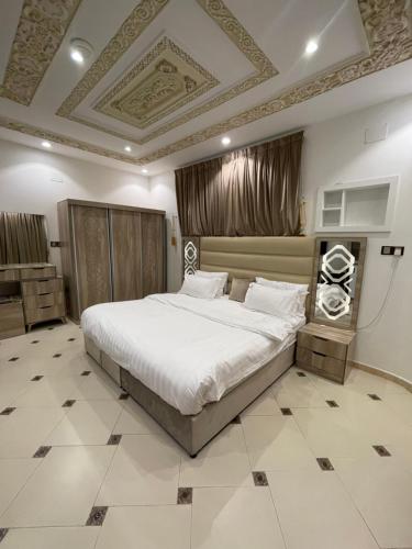 a bedroom with a large bed and a coffered ceiling at Friday Suites in AlUla
