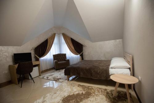 um quarto com uma cama, uma secretária e uma televisão em Premiera em Svalyava