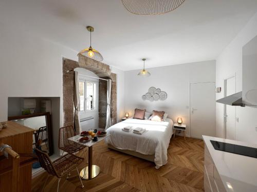 a bedroom with a bed and a table in a room at Le Petit Palais Notre Dame - Heart of Dijon - With AC in Dijon