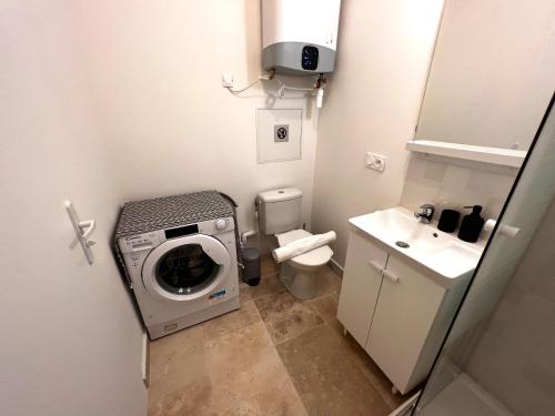a small bathroom with a washing machine and a sink at Le Petit Palais Notre Dame - Heart of Dijon - With AC in Dijon
