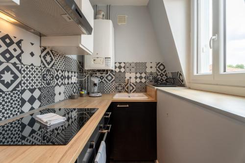 una cocina con azulejos blancos y negros en la pared en CasaVasca - Appartement Cosy et Calme, WiFi - Parking, en Hendaya