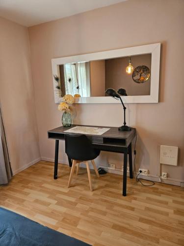 a desk with a lamp and a mirror in a room at La citadelle in Nyons