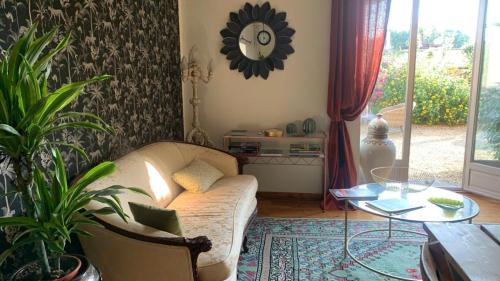 a living room with a couch and a table at TENDANCE CAMPAGNE Chambre d'hôtes in Marillac