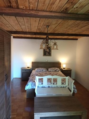 a bedroom with a white bed and wooden ceilings at Apartma Brina 3 in Sežana