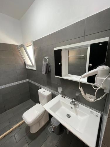 a bathroom with a white toilet and a sink at Essos Villas in Dhërmi