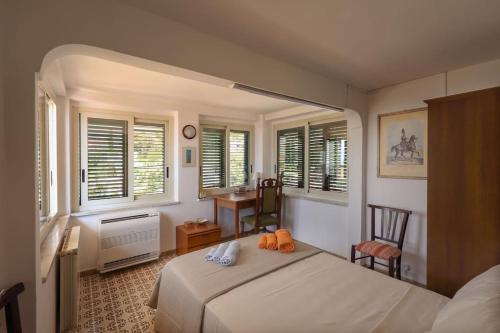 Schlafzimmer mit einem Bett, einem Schreibtisch und Fenstern in der Unterkunft Chez Pancrazio in Taormina