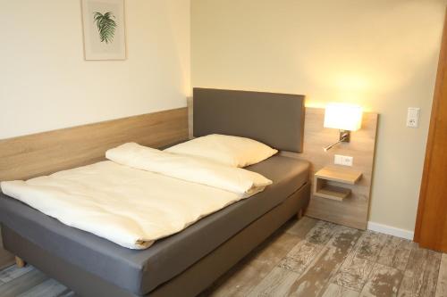 a bed with two pillows on it in a room at Kemnater Hof Apartments in Ostfildern
