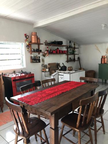 eine Küche mit einem Holztisch und Stühlen drumherum in der Unterkunft Hospedaria Rural Recanto Verde dos Canyons in Praia Grande