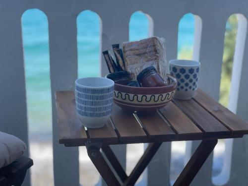 a table with two cups and a bowl on it at Vera Mare in Agia Marina