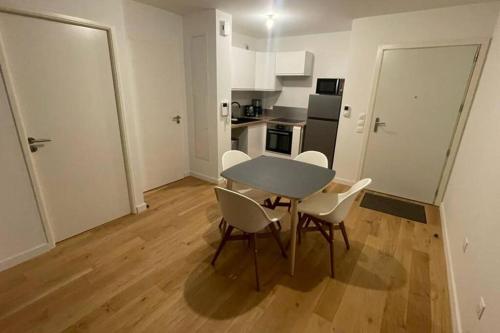 une cuisine et une salle à manger avec une table et des chaises dans l'établissement Superbe appartement T2 à Arras., à Arras