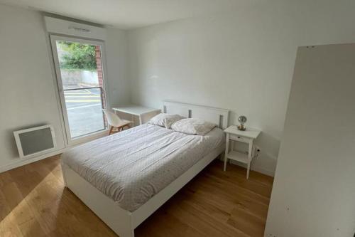 une chambre blanche avec un lit et une fenêtre dans l'établissement Superbe appartement T2 à Arras., à Arras