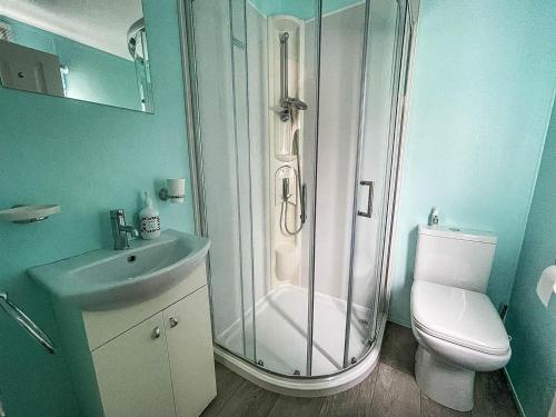 y baño con ducha, aseo y lavamanos. en Stunning Lodge With Decking At Oaklands Holiday Park In Essex Ref 39017rw en Clacton-on-Sea