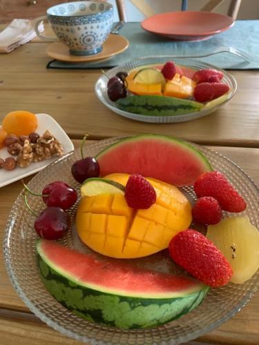 a plate of fruit on a wooden table at TENDANCE CAMPAGNE Chambre d'hôtes in Marillac