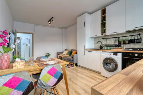 a kitchen and living room with a table and chairs at Homie Studio Apartment - Private Parking - Self Check-In in Bucharest