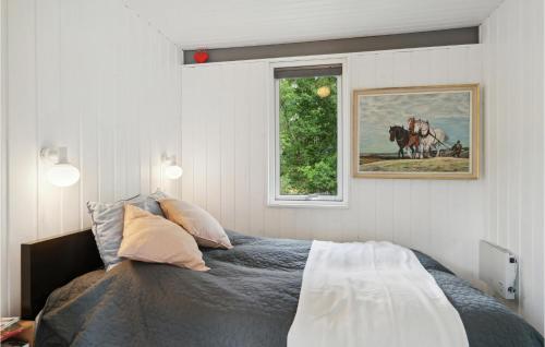 een slaapkamer met een bed en een raam met een paardenfoto bij 2 Bedroom Amazing Home In Allingbro in Allingåbro