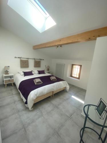 1 dormitorio con 1 cama grande y tragaluz en L’auberge de Montsalier en Le Plan