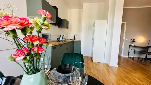 een vaas met bloemen op een tafel in een keuken bij Apartment FLORA in Halle an der Saale in Halle an der Saale