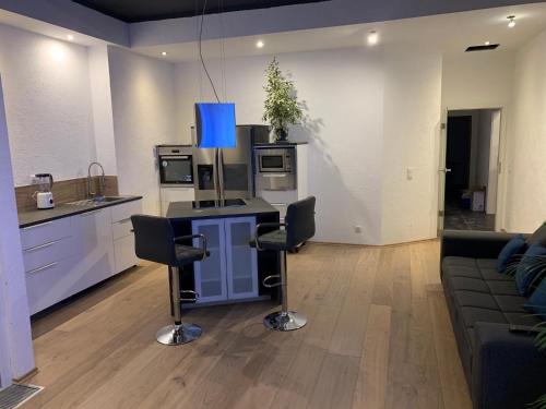 a living room with a kitchen and a table with chairs at Allgäu Loft Obermaiselstein in Obermaiselstein