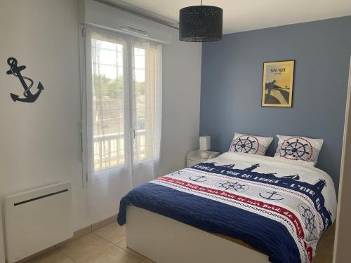 a bedroom with a bed with blue walls and a window at Résidence Fort de l'Eve - T2 à 300m plage M Hulot, chemin côtier, commerces - St Marc sur Mer proche La Baule Ponichet in Saint-Nazaire