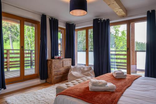 une chambre avec un lit et une grande fenêtre dans l'établissement Chalet Les Oréades - Penthouse Duplex Apartment, aux Gets