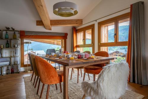 une salle à manger avec une table et des chaises en bois dans l'établissement Chalet Les Oréades - Penthouse Duplex Apartment, aux Gets