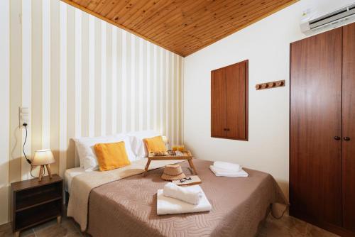 1 dormitorio con 1 cama con techo de madera en Apironero Plouti House en Ploutí
