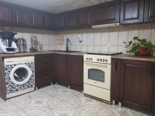 a kitchen with a stove and a washing machine at Casa Eby in Vidolm
