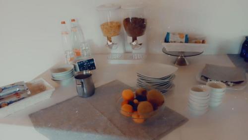 un tazón de naranjas en un mostrador con platos en B&B in Fattoria, en Berzo San Fermo