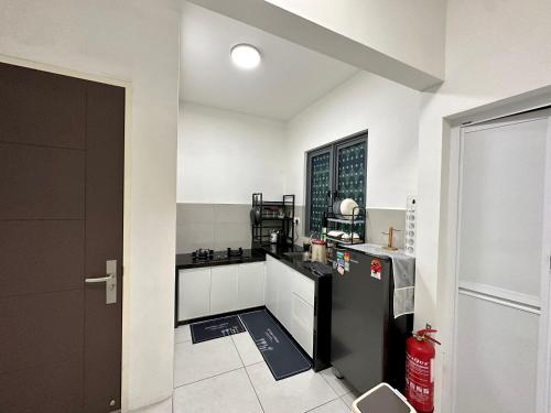a small kitchen with a black and white appliance at Holiday Inn Stay 3B2R Meritus Residensi Perai in Perai