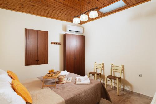 a room with a bed and a table and chairs at Apironero Plouti House in Ploutí