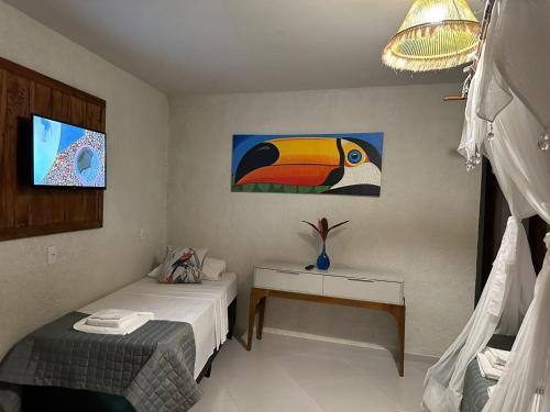 a bedroom with two beds and a painting on the wall at Pousada Preciosa do Arraial - com Natura e L'Occitane - recém inaugurada in Arraial d'Ajuda