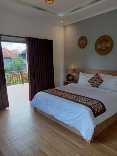 a bedroom with a large bed and a large window at Karma House in Ubud
