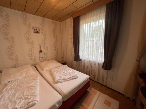 2 camas en una habitación pequeña con ventana en Ferien-Bungalow im Seebad UeckermündeOT Bellin - a68650, en Ueckermünde