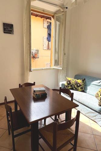 een tafel en stoelen in een woonkamer met een bank bij Appartamento centrale con vista su montagna in Porretta Terme