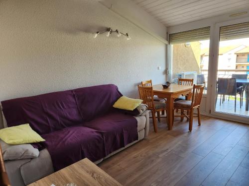 un salon avec un canapé violet et une table dans l'établissement Cocoon La Londe M2, à La Londe-les-Maures